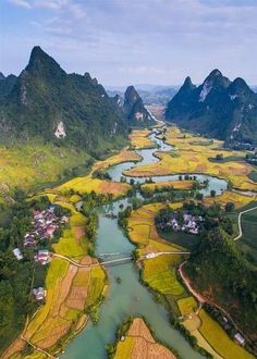 an aerial view of rice fields in the mountains and river running through them, surrounded by greenery