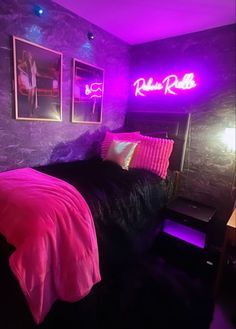 a bedroom with purple lighting and pictures on the wall