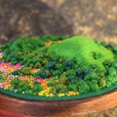 a wooden bowl filled with green and pink sprinkles