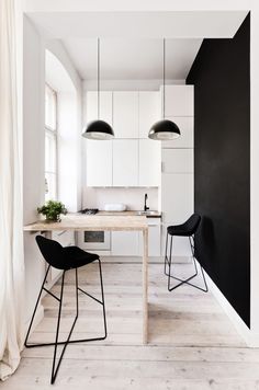 two black and white chairs sitting in front of a table