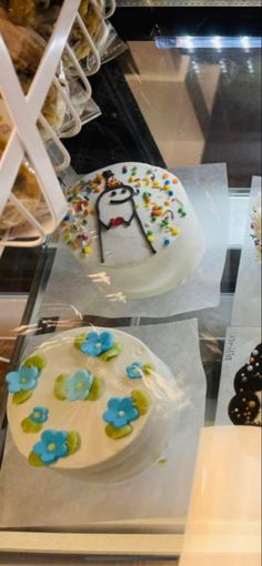 there are many different cakes on display in the glass case, including one with a cake topper