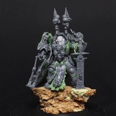 a grey and green painted warhammer sitting on top of a rock with two swords