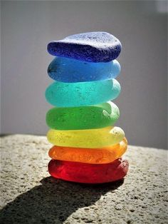 a stack of colorful rocks sitting on top of a rock