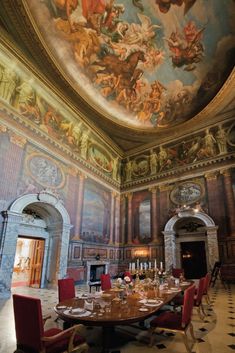 an ornate dining room with paintings on the ceiling