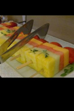 there are several popsicles with fruit on them and one has a knife sticking out of it