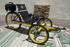 a yellow and black tricycle parked next to a pile of bricks on the ground