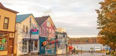 a row of shops on the side of a street next to a body of water