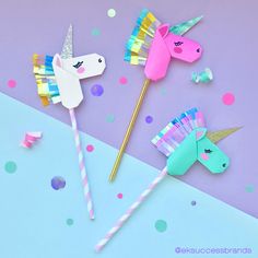 paper unicorn wands are on a purple and blue background