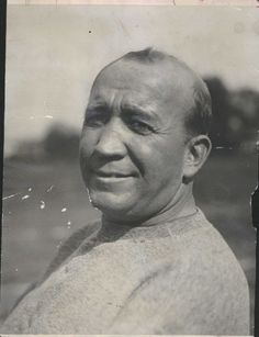 an old black and white photo of a man with a bald head wearing a sweater