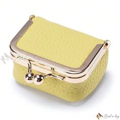 a small yellow purse with two metal handles