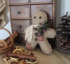 a gingerbread man made out of orange slices and cinnamons next to some pine cones