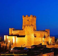 an old castle lit up at night with lights on it's walls and windows