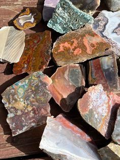 many different types of rocks on a wooden surface with one rock in the middle and another stone out front