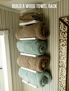 three towels are hanging on the wall in front of a mirror with text overlay that reads build a wood towel rack