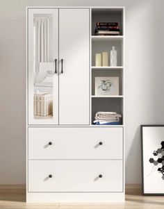 a white bookcase with two drawers and some pictures on the wall next to it