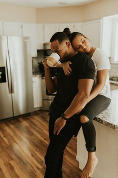 a man and woman are hugging in the kitchen