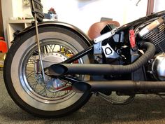 a motorcycle parked in a garage with its exhaust system exposed