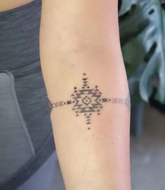 a woman's arm with a tattoo design on the left side of her arm