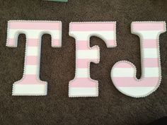 the letters are made out of pink and white stripes