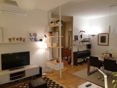 a living room filled with furniture and a flat screen tv on top of a hard wood floor