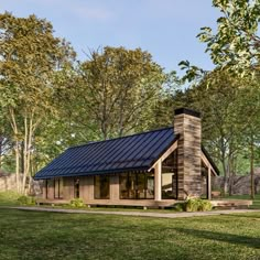 a small house with a metal roof in the middle of a field and trees around it