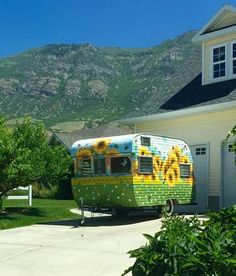 an rv parked in front of a house with mountains in the background