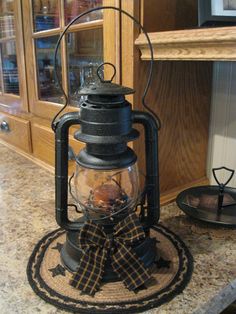 an old fashioned lantern with a bow on the front is sitting on a kitchen counter