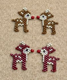 three beaded reindeers sitting on top of a floor next to each other with red beads