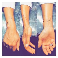 two hands with small tattoos on them