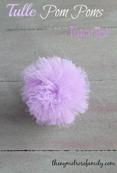 a purple pom - pom sitting on top of a wooden floor with the words tulle pom poms written below it