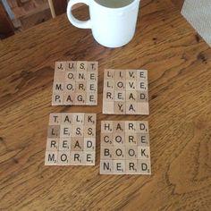 several scrabbles are arranged on a table next to a coffee cup