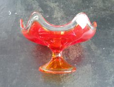 a red glass vase sitting on top of a table