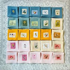 a wall hanging made up of squares with flowers on them and the words hello written in each square