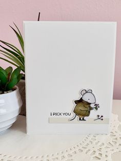 a card with a mouse on it next to a potted plant