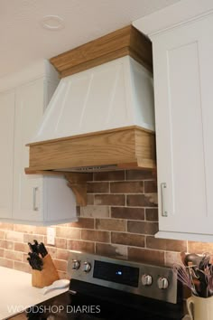 a stove top oven sitting inside of a kitchen next to white cabinets and counter tops