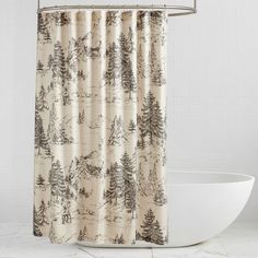 a shower curtain with trees on it and a white bathtub in front of it