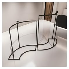 three curved glass displays in a white room with black metal frames on the wall and floor