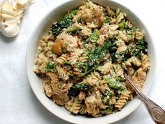 a white bowl filled with pasta and vegetables