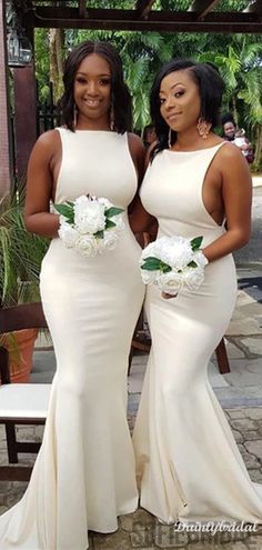 two women in white dresses standing next to each other