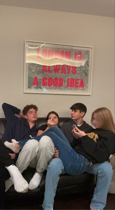 four people sitting on a couch playing video games