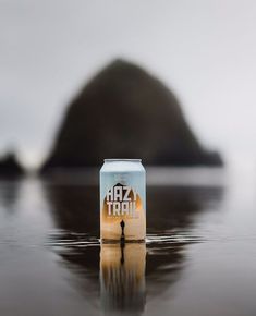 a can of beer sitting on top of a wet surface