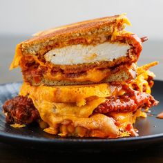 two sandwiches stacked on top of each other with cheese and meat in between the buns