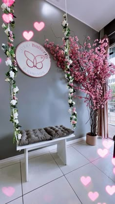 a white bench with pink flowers on it in front of a sign that says love