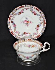 an ornately decorated tea cup and saucer with matching saucer, on a black background