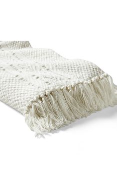 a white blanket with fringes on it