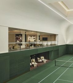 an indoor tennis court is shown with chairs and tables in the center, along with other furniture