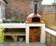 an outdoor pizza oven with logs in it