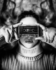 a woman holding an old fashioned radio in front of her face