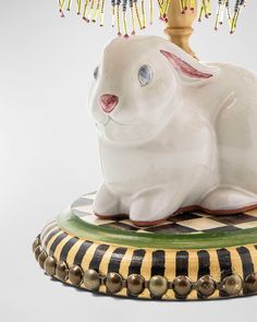 a white rabbit figurine sitting on top of a checkerboard tablecloth