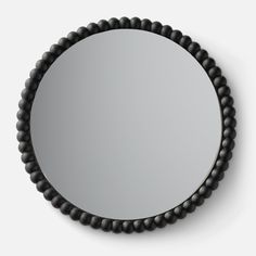 a round mirror with beaded trim around it